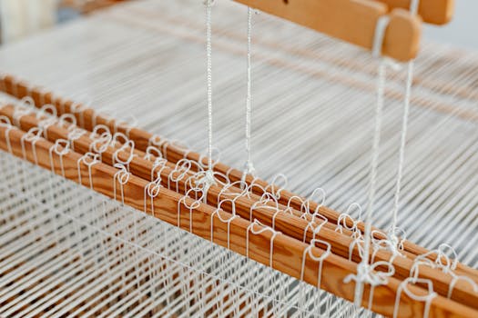 Detailed view of a wooden weaving loom with threads, showcasing traditional craftsmanship.