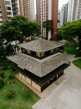 Discover the beautiful Japanese Pavilion in Curitiba's Praça do Japão, framed by modern high-rises.